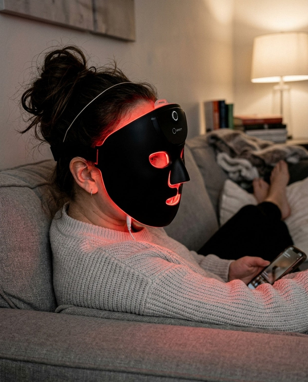 Woman wearing Lifinity GloWave LED and PEMF facial mask at home