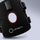 A close-up of a black LIFINITY support brace with adjustable straps, a circular cutout showing a red inner lining, and a small rectangular electronic control unit attached near the top.