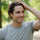 Man in a gray t-shirt with a blurred green background